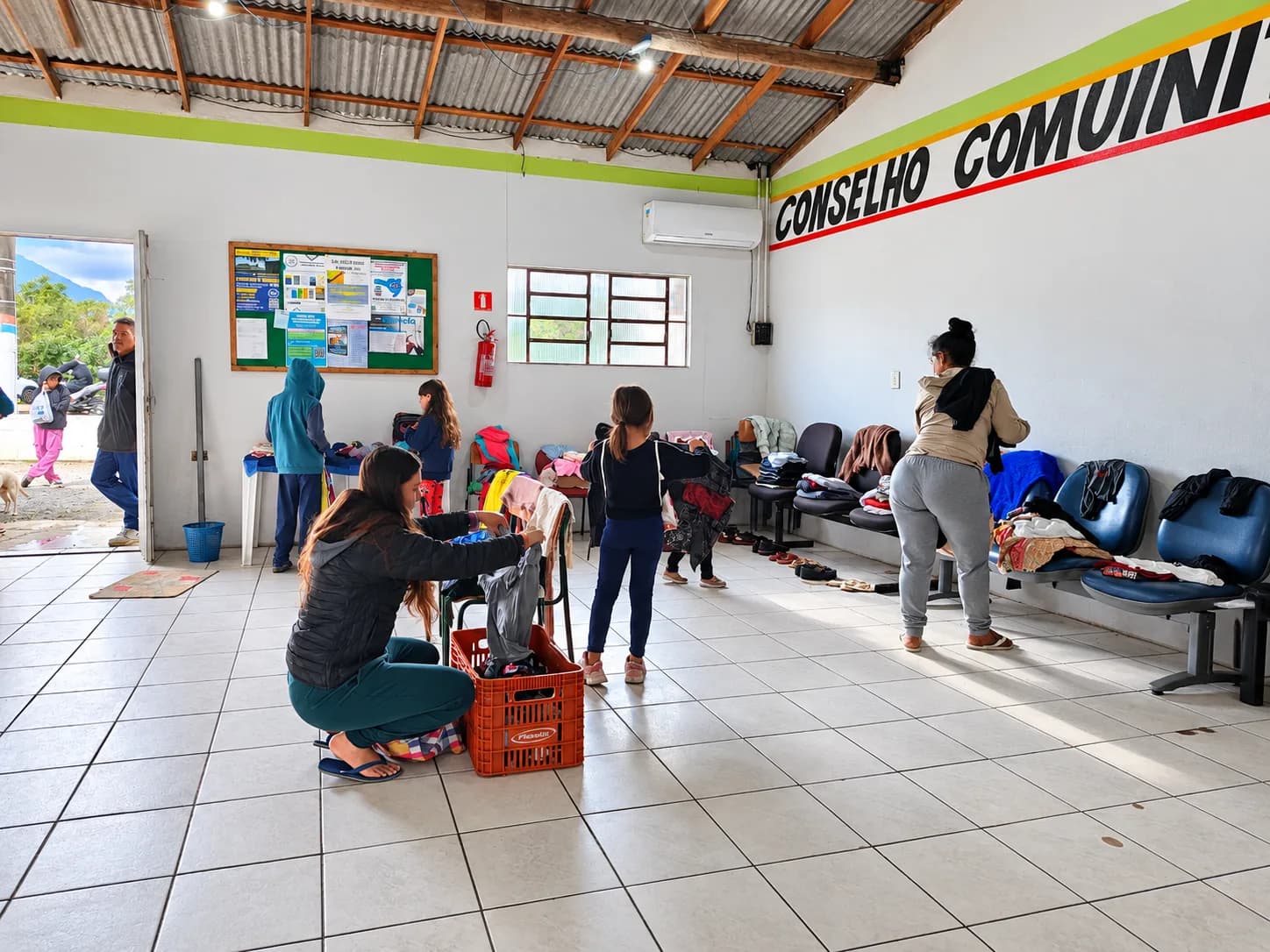 Voluntárias organizando roupas doadas durante ação comunitária do Nós na Rua na Tapera.